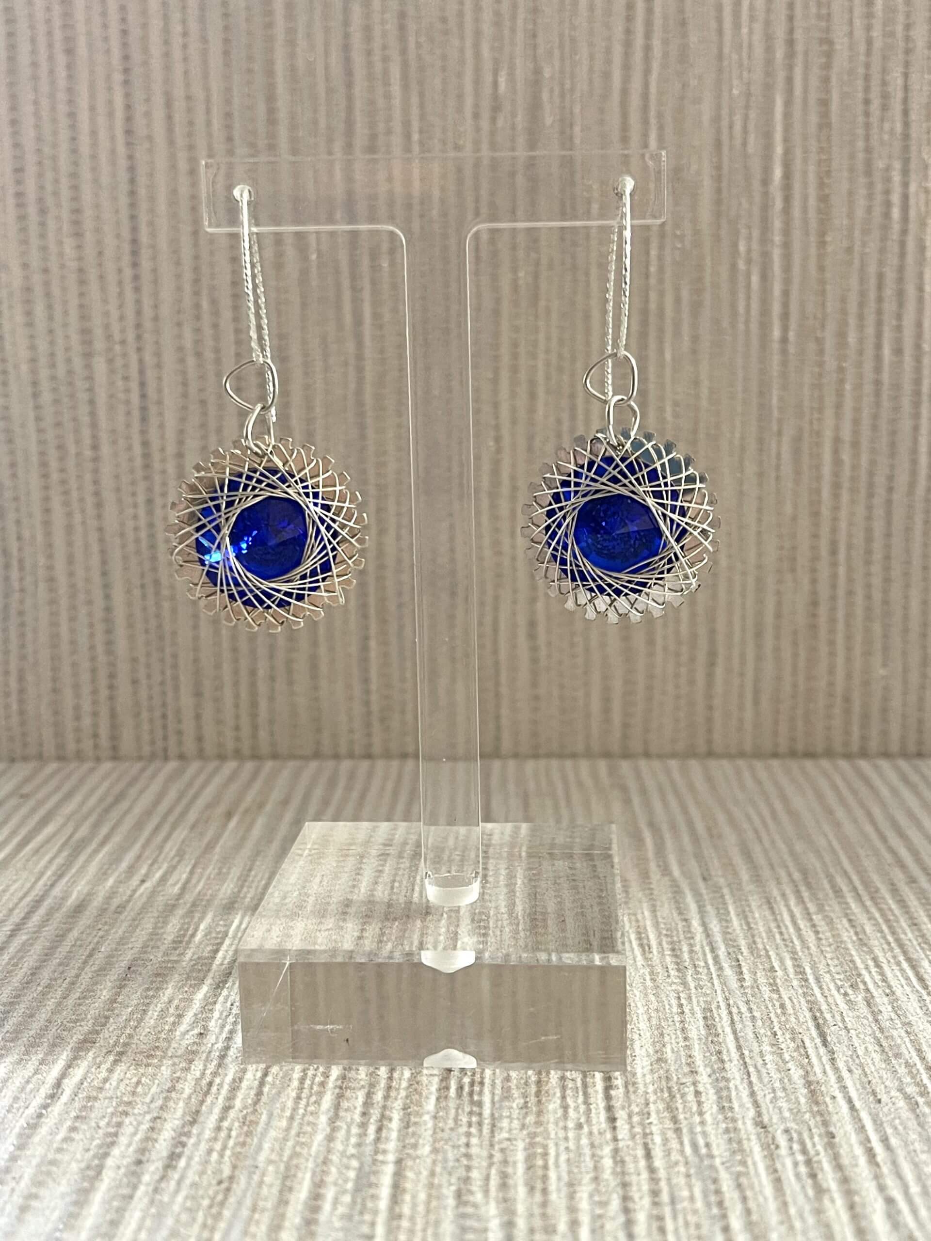 Earrings featuring blue gemstones with wrapped in a wire design designed by Melissa Panszi-Riebe of A D'Zine.