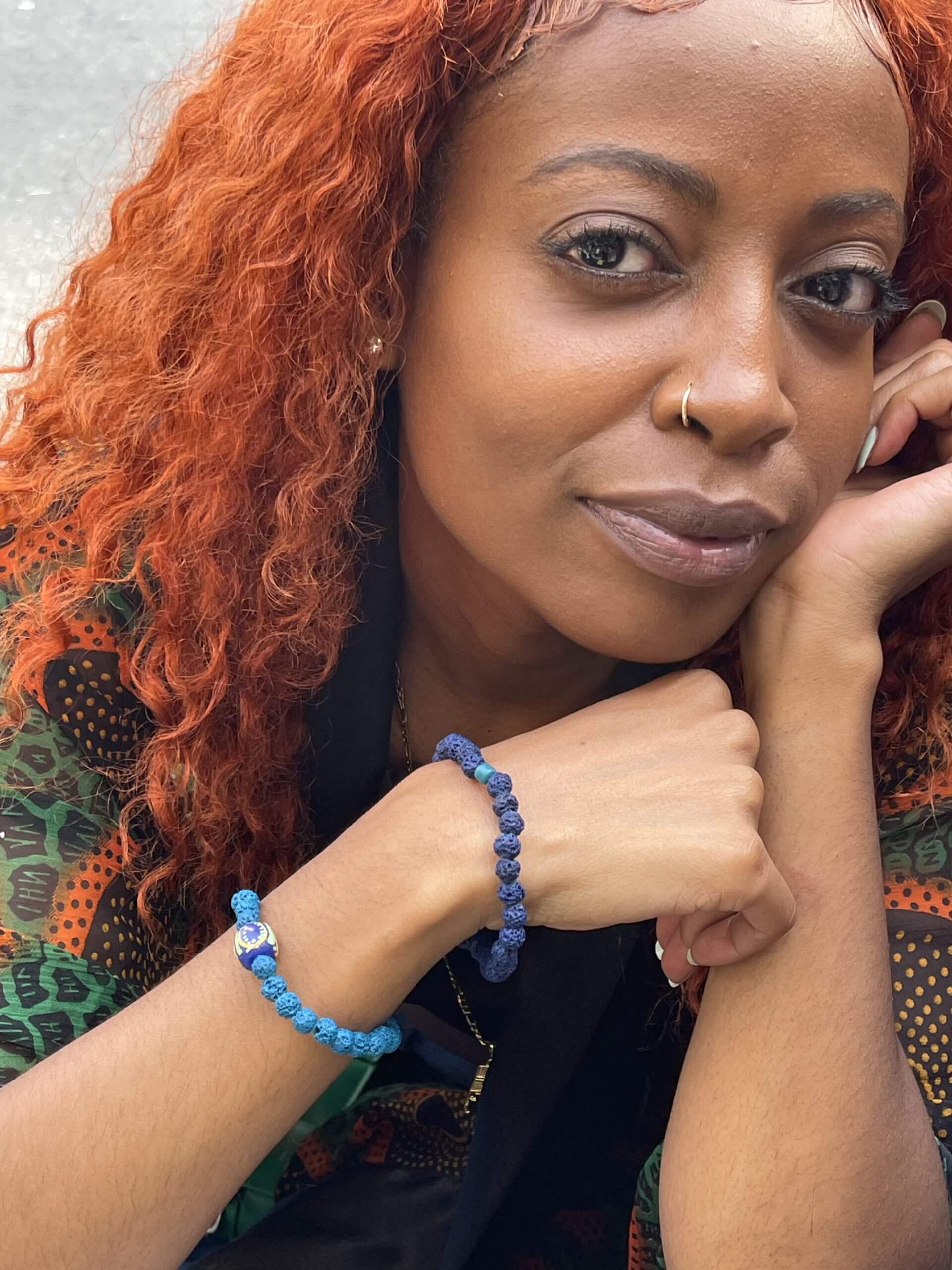 A woman models two beaded bracelets in different shades of blue designed by Melissa Panszi-Riebe of A D'Zine.