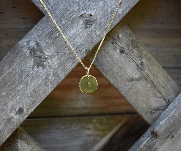 Idea for DIY Mother's Day Gifts: Image shows a hand stamped initial necklace in gold.