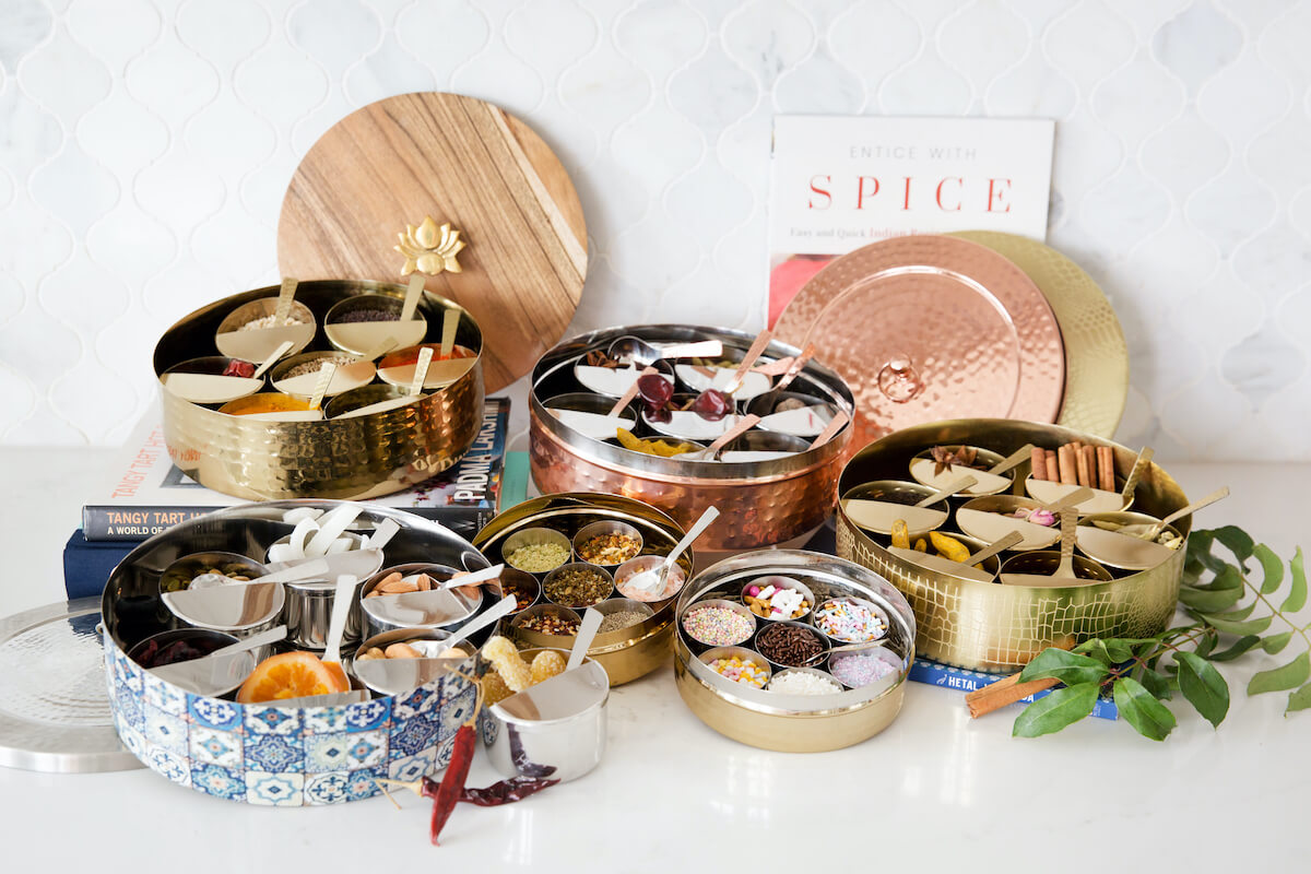 Golden, copper and patterned tins for holding spices designed by Sushmitha Pidatala of Arjuna Design Studio. 